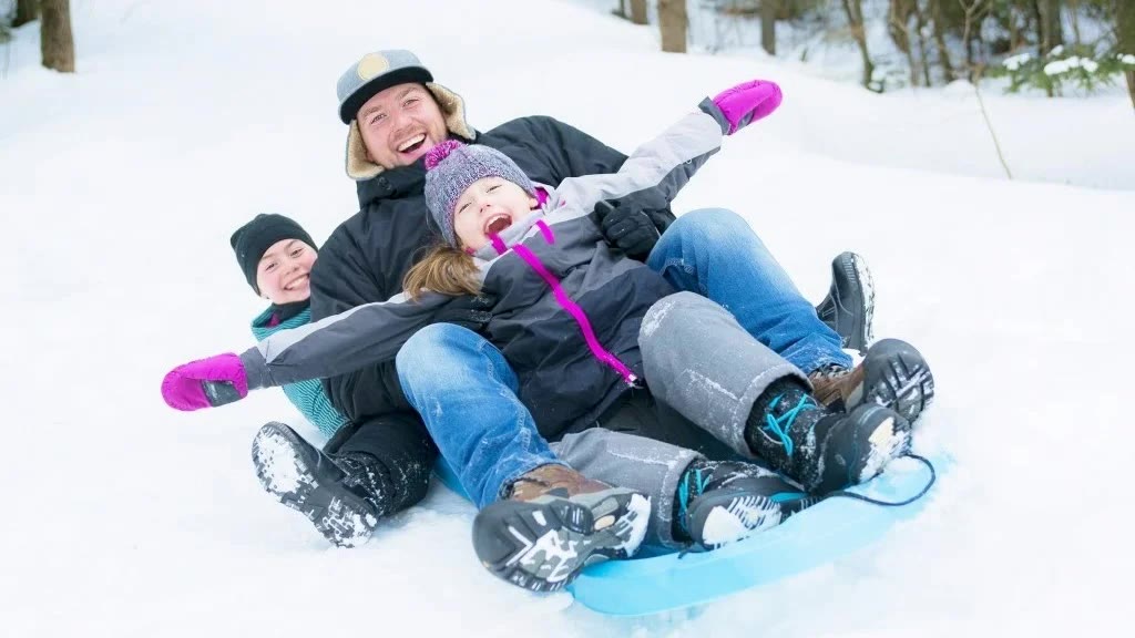Family enjoying a snow sledding ride